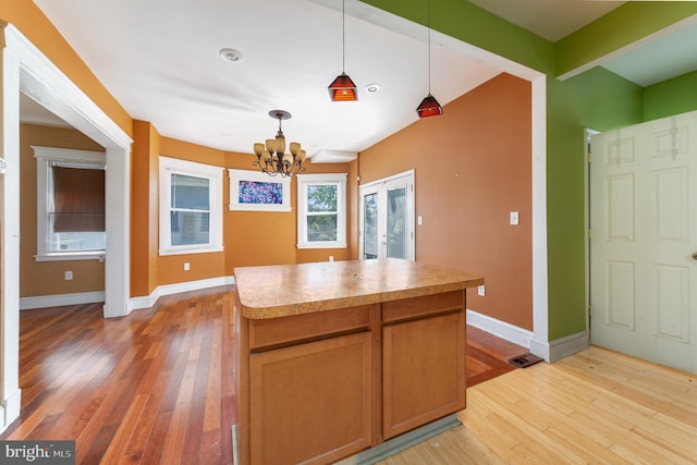 kitchen with an inviting chandelier, baseboards, and light wood-style flooring