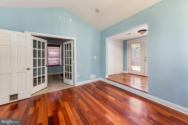 entryway featuring baseboards, french doors, wood finished floors, and lofted ceiling