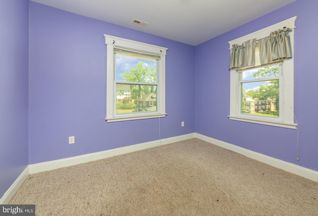 unfurnished room featuring carpet floors, baseboards, and visible vents