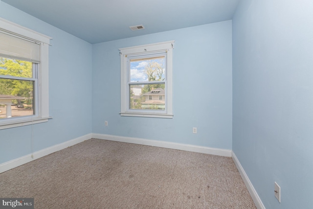 carpeted spare room with baseboards and visible vents