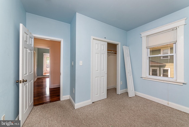unfurnished bedroom with carpet flooring, baseboards, and a closet