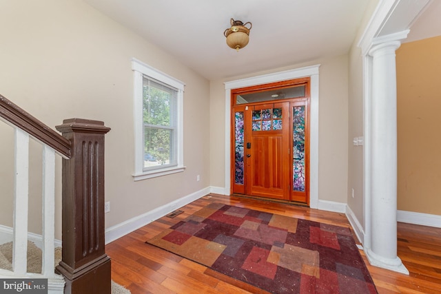 entryway with stairs, baseboards, decorative columns, and wood finished floors