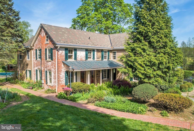 colonial home with a front lawn and brick siding