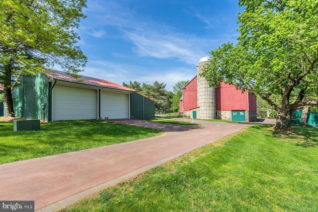 view of yard featuring a barn, an outdoor structure, and a garage