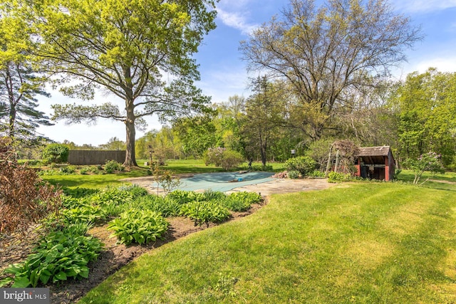view of yard with fence, an outdoor structure, and a shed