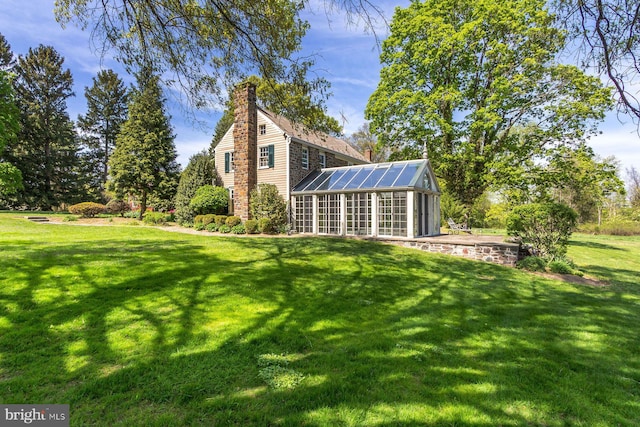 view of yard featuring a greenhouse and an outbuilding