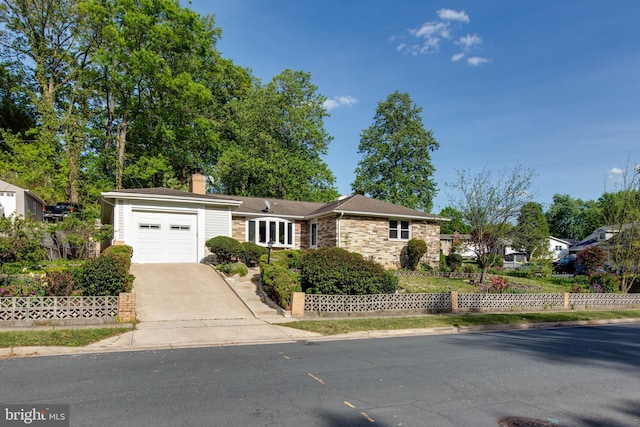 single story home with an attached garage, a chimney, concrete driveway, and stone siding