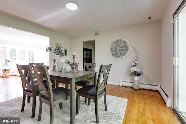 dining space with baseboards, light wood-style flooring, and visible vents
