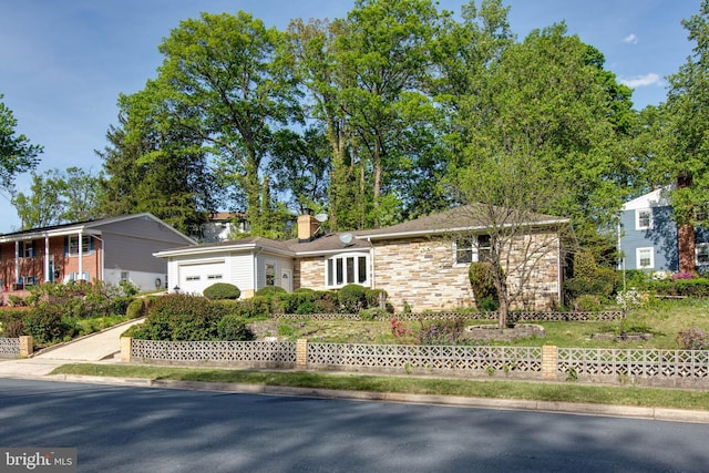 ranch-style house with fence, an attached garage, a chimney, and stone siding