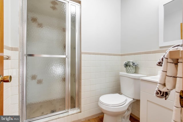 bathroom featuring vanity, tile walls, a wainscoted wall, and a stall shower