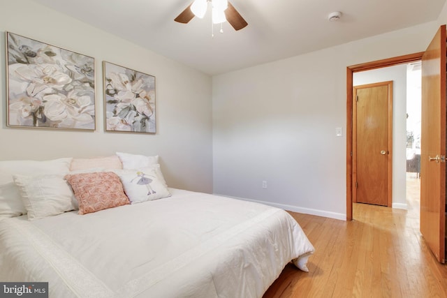 bedroom with a ceiling fan, baseboards, and light wood-style flooring