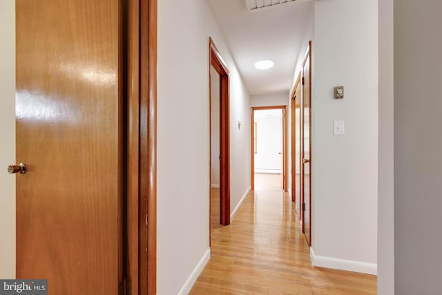 hallway with baseboards and light wood-type flooring