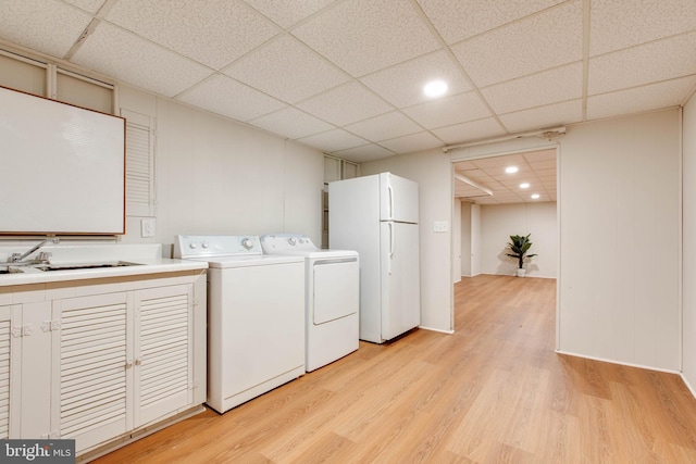 clothes washing area with laundry area, recessed lighting, washing machine and clothes dryer, a sink, and light wood finished floors