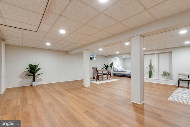 finished below grade area featuring recessed lighting, a paneled ceiling, and wood finished floors