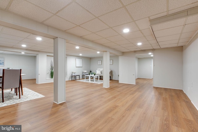 finished basement featuring recessed lighting, a paneled ceiling, and light wood-type flooring