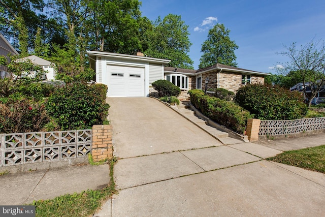 ranch-style home with fence, a chimney, concrete driveway, and a garage