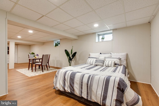 bedroom with recessed lighting, light wood-style flooring, and a drop ceiling