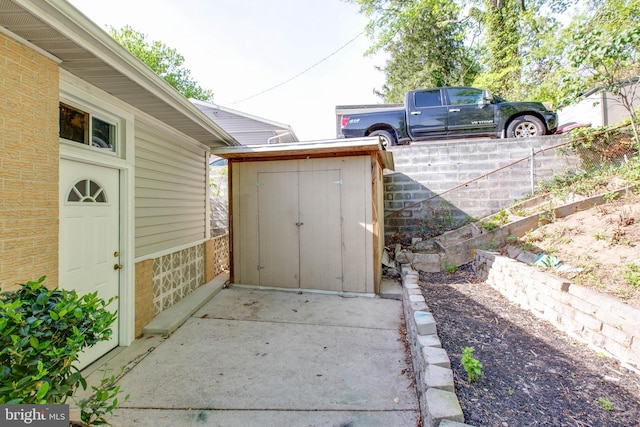 exterior space with fence, an outbuilding, and a storage unit