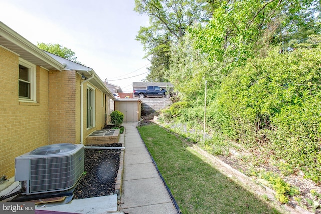 view of yard with central air condition unit, an outbuilding, and a shed