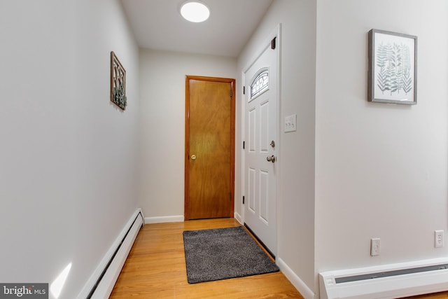 doorway to outside featuring light wood-style floors, baseboards, and a baseboard radiator