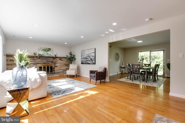 living area featuring baseboards, wood finished floors, and a fireplace