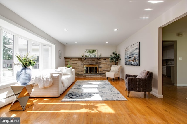 living area with baseboards, a fireplace, recessed lighting, and wood finished floors
