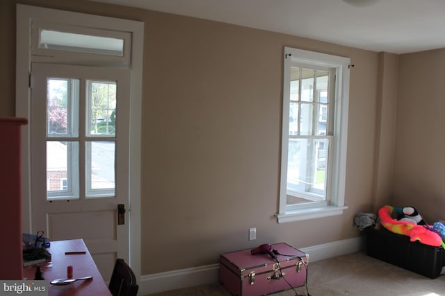doorway featuring baseboards and carpet floors