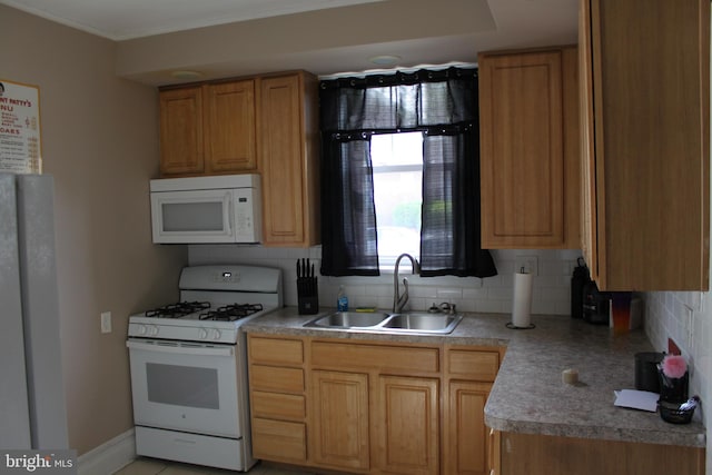 kitchen featuring a sink, decorative backsplash, and white appliances