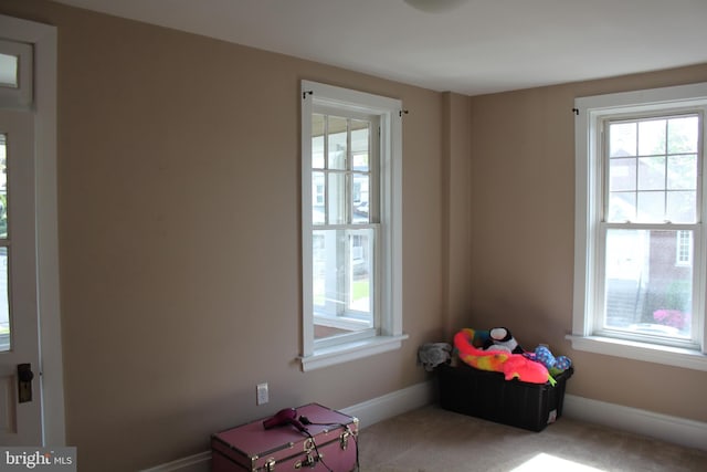 recreation room featuring baseboards, carpet flooring, and a wealth of natural light