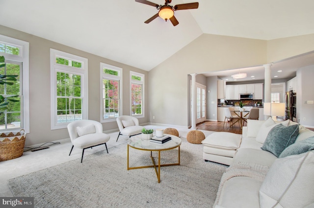 7820 Elsinore Dr, Manassas, VA 20112 - living area featuring decorative columns, baseboards, ceiling fan, high vaulted ceiling, and light colored carpet