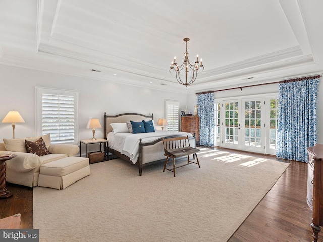 bedroom with an inviting chandelier, access to outside, ornamental molding, multiple windows, and a raised ceiling