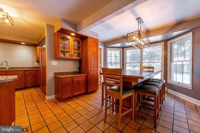 dining space featuring baseboards, a wealth of natural light, and light tile patterned floors