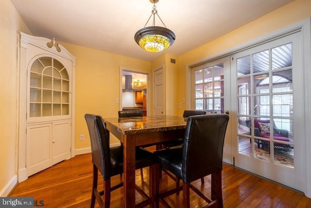 dining area with hardwood / wood-style flooring, baseboards, and visible vents