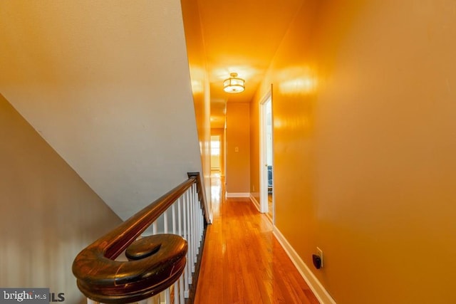 corridor with baseboards and wood finished floors