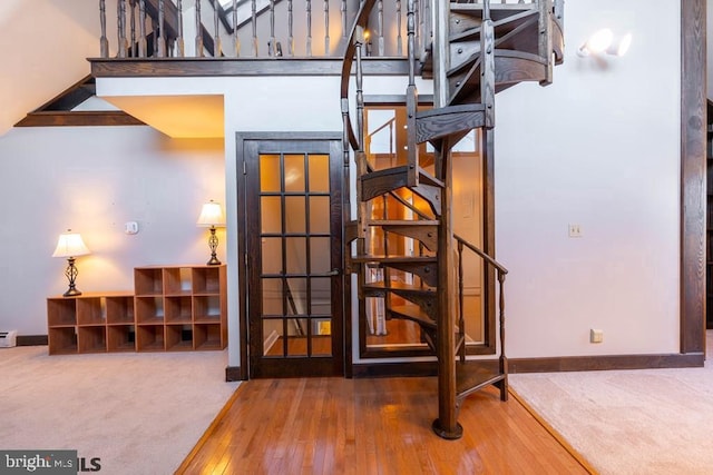 staircase with hardwood / wood-style floors, carpet floors, and baseboards