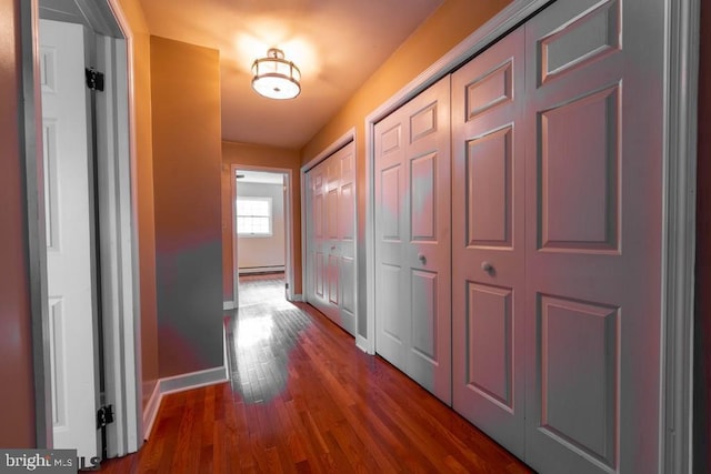 corridor with dark wood finished floors and baseboards