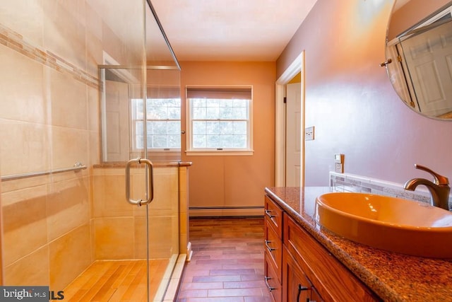full bath with vanity, baseboard heating, and a stall shower