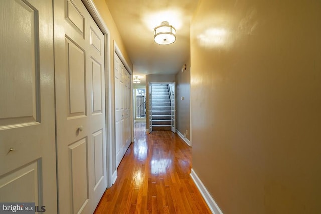 corridor featuring wood finished floors and baseboards