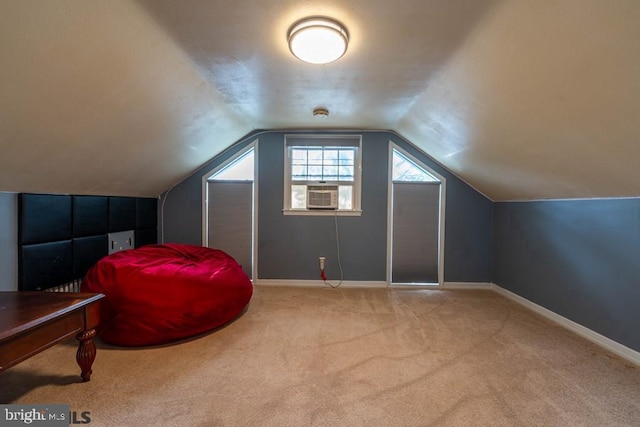 additional living space with baseboards, vaulted ceiling, cooling unit, and carpet