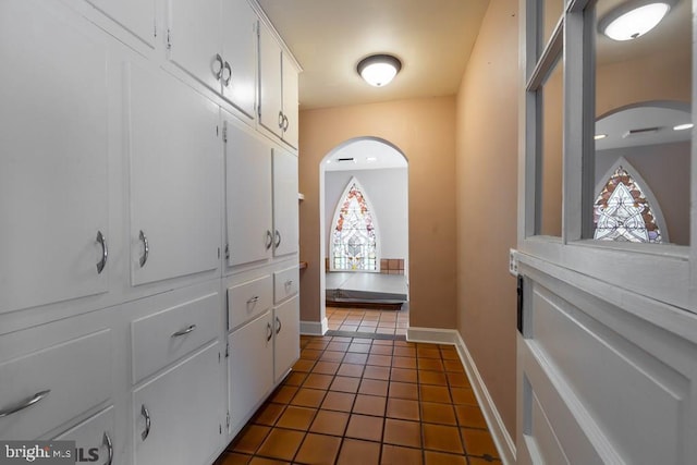interior space with plenty of natural light, baseboards, and dark tile patterned flooring