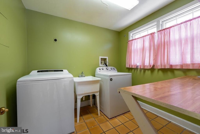 laundry room featuring washing machine and clothes dryer, light tile patterned flooring, and laundry area