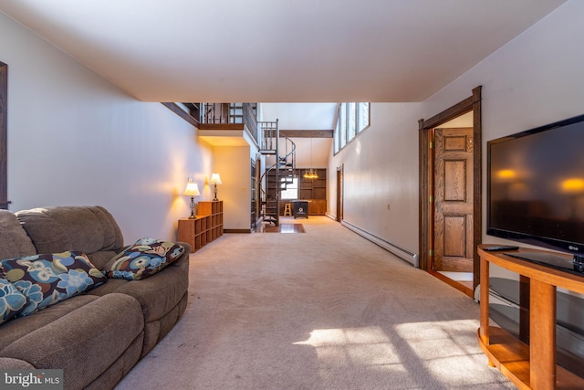 living area featuring baseboards, carpet, stairs, and baseboard heating