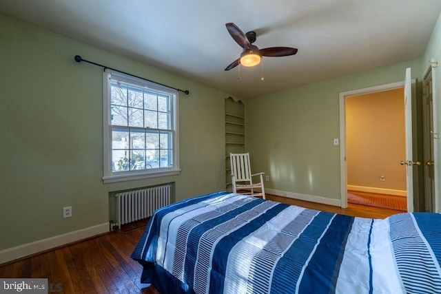 bedroom featuring radiator, baseboards, wood finished floors, and ceiling fan