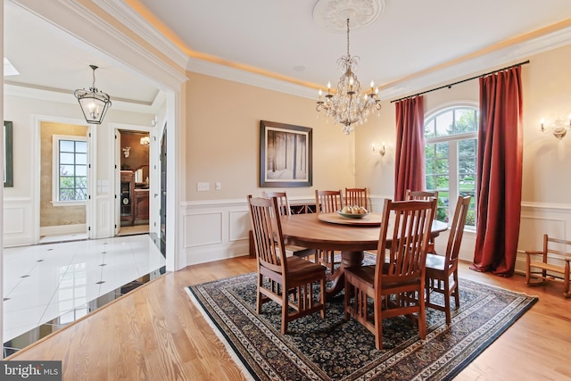 dining space with a healthy amount of sunlight, an inviting chandelier, and a decorative wall