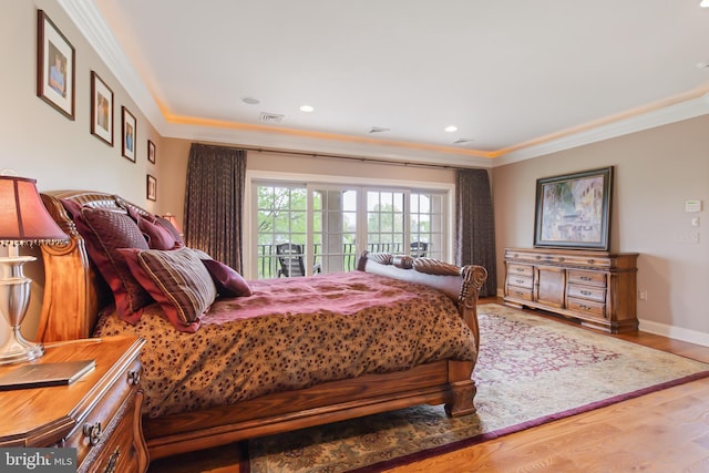 bedroom with wood finished floors, access to outside, baseboards, visible vents, and crown molding