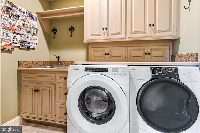 washroom featuring washer and clothes dryer, cabinet space, and a sink