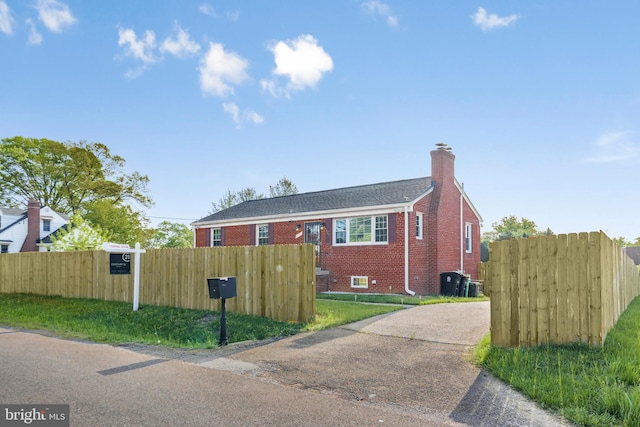 2124 Weber Dr, District Heights, MD 20747 - view of front of property with a chimney, central AC unit, a fenced front yard, driveway, and brick siding
