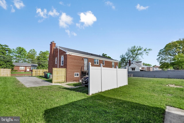 2124 Weber Dr, District Heights, MD 20747 - rear view of property with a chimney, brick siding, fence, and a yard