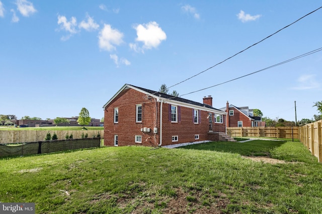 2124 Weber Dr, District Heights, MD 20747 - back of house with a lawn, a fenced backyard, a chimney, and brick siding