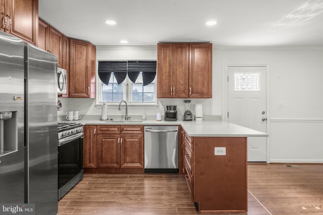 2124 Weber Dr, District Heights, MD 20747 - kitchen with a peninsula, a sink, appliances with stainless steel finishes, dark wood-type flooring, and ornamental molding